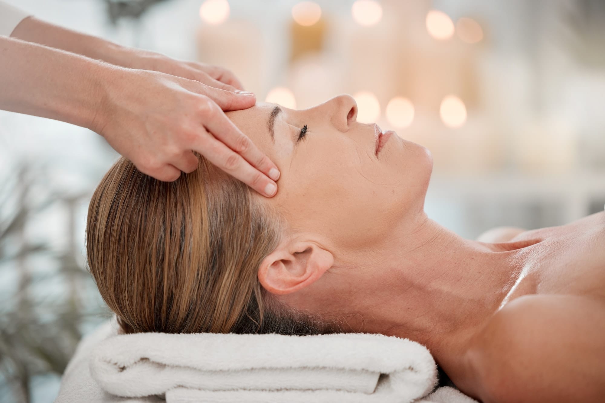 Helping to center her thoughts. Shot of a woman receiving a temple massage at a spa.